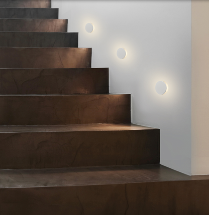 Applique murale LED au design minimaliste, diffusant une lumière douce et rassurante pour éclairer couloirs et escaliers avec élégance et sobriété.