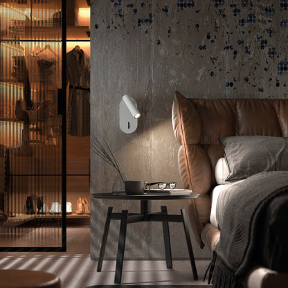 Applique murale LED blanche modèle DIRK, en acier et PMMA, fixée sur un mur en bois clair. Son spot orientable diffuse une lumière de lecture douce et ciblée, idéale pour les chambres et les salons modernes.