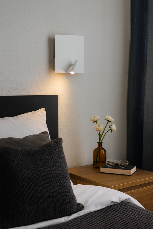 Applique murale LED blanche de la famille Baltic, au design minimaliste et fonctionnel, installée dans un coin lecture moderne. Dotée d’un spot orientable et d’un port USB intégré, elle diffuse une lumière douce et précise idéale pour les chambres.