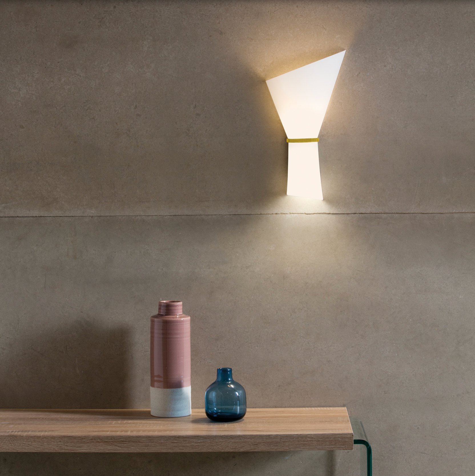 Applique murale Perla au design minimaliste, sublimée par une touche dorée ou chromée, diffusant une lumière douce et enveloppante pour une ambiance élégante et apaisante au quotidien.