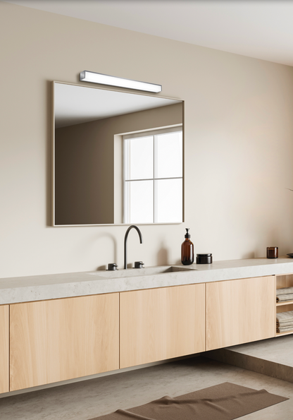 Applique murale Tavi au design moderne et discret, diffusant une lumière douce et précise au-dessus du miroir, idéale pour une salle de bain élégante et apaisante.