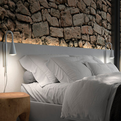 Applique murale Tear installée de chaque côté d’un lit au design moderne, diffusant une lumière douce et ciblée grâce à son abat-jour conique blanc et son diffuseur en verre transparent, créant une ambiance chaleureuse et élégante.