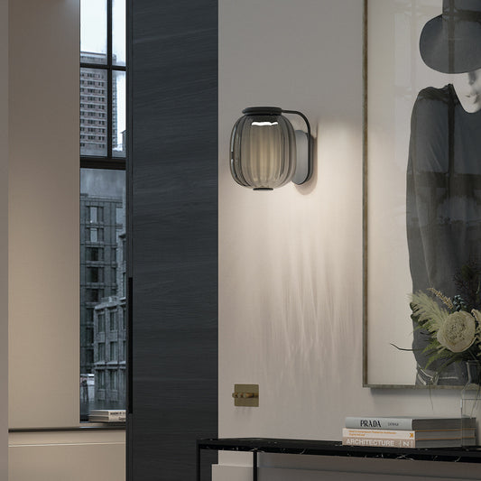 Applique murale design Krista en verre fumé et acier noir, installée dans un intérieur moderne et élégant.