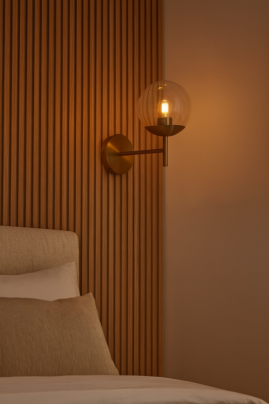 Applique murale design en acier doré avec globe en verre transparent, issue de la collection Oxy, idéale pour les intérieurs élégants et contemporains.