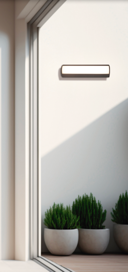 Applique murale extérieure Aka en aluminium noir, au design moderne et discret, diffusant une lumière douce et uniforme grâce à son diffuseur opale, résistante et durable.