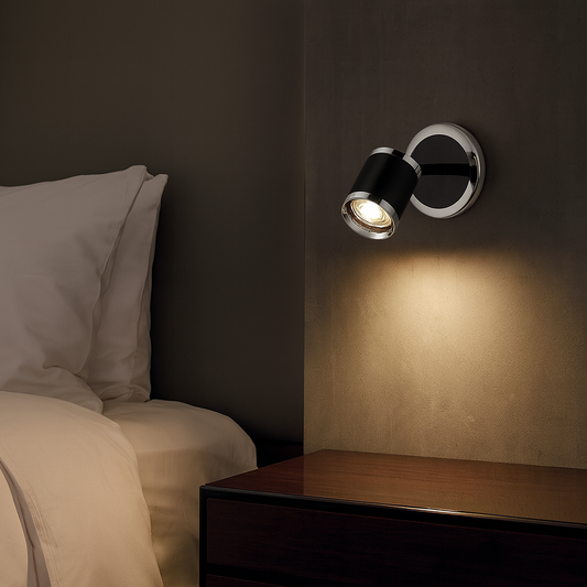 Applique murale orientable en aluminium noir et chrome, avec spot directionnel. Design moderne et élégant, idéale pour les salons, chambres ou espaces contemporains.