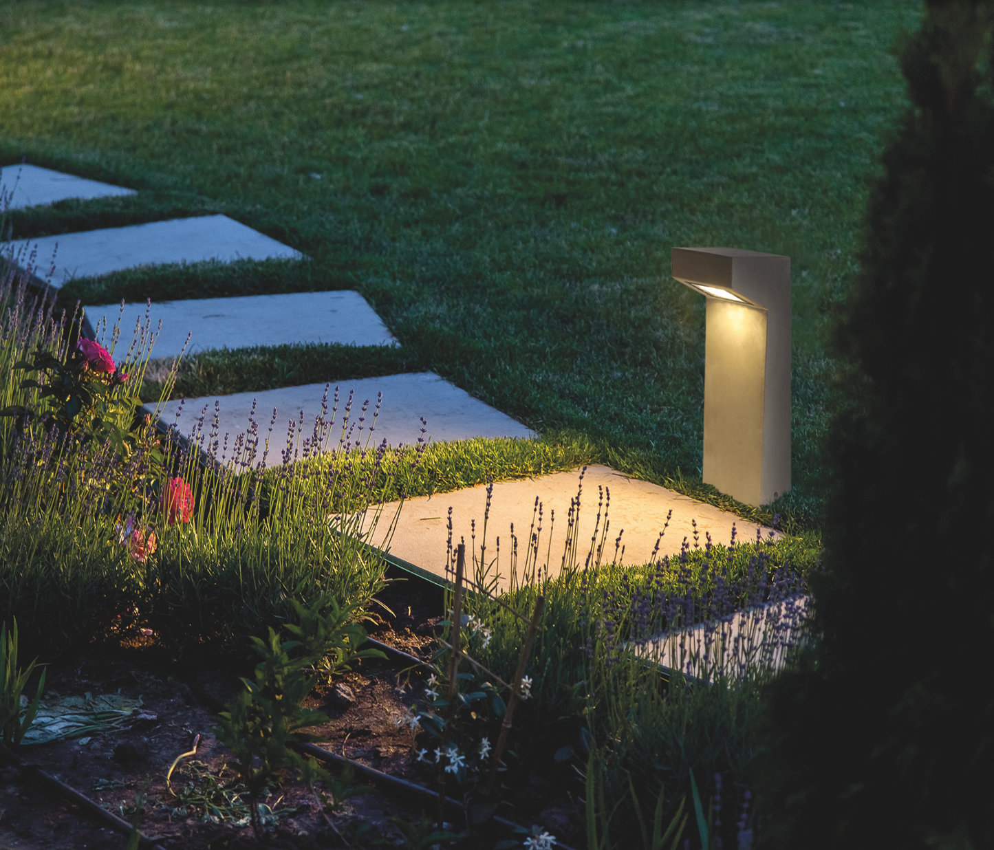 Borne lumineuse extérieure Izar en finition gris ciment, design minimaliste et moderne, diffusant une lumière douce et chaleureuse résistante aux intempéries IP65.