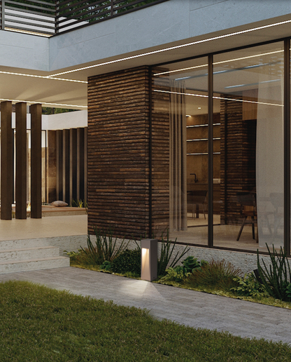 Borne lumineuse extérieure Perseo en finition gris ciment, design minimaliste et contemporain, diffusant une lumière chaude et apaisante résistante aux intempéries.