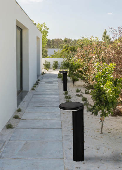 Borne solaire extérieure Gloss au design moderne, avec capteur de luminosité et recharge autonome, diffusant une lumière chaude et durable résistante aux intempéries IP65.