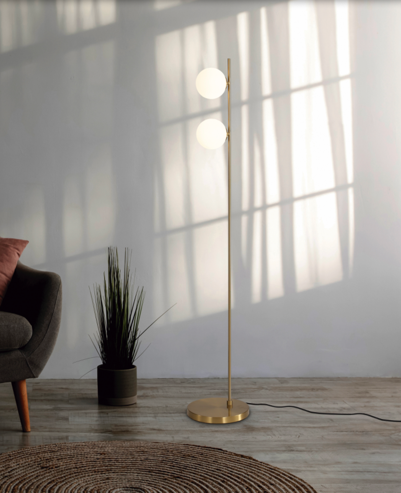 Lampadaire au design fin et minimaliste, doté de deux sources lumineuses diffusant une lumière douce et uniforme, idéal pour créer une ambiance apaisante et élégante dans un salon ou un espace détente.