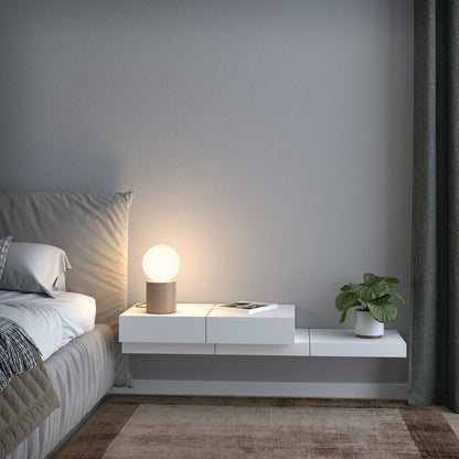 Lampe design Geometrical avec bois naturel et verre opalin, diffusant une lumière douce dans un intérieur moderne et chaleureux.