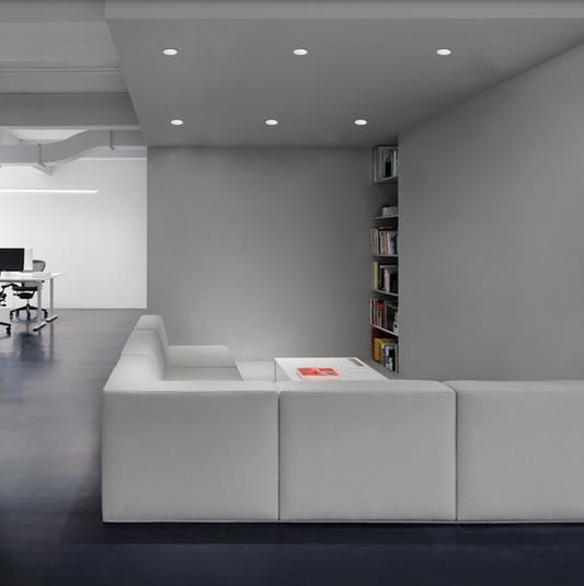 Spot encastré Nork au design rond et minimaliste, finition blanche, diffusant une lumière douce et chaleureuse idéale pour terrasses et espaces modernes.